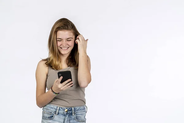 Vacker Blond Tonårs Modell Leker Med Hennes Telefon Studiomiljö — Stockfoto