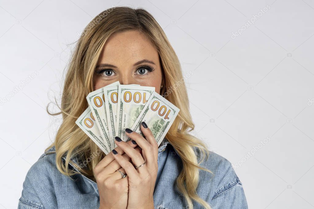 A gorgeous blonde model posing with United States currency
