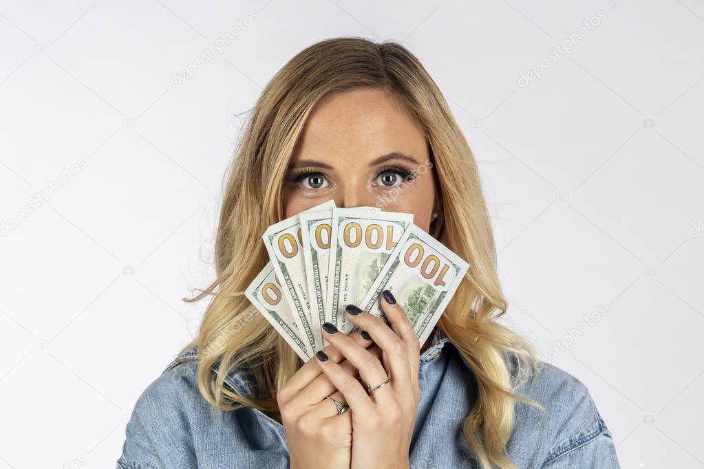A gorgeous blonde model posing with United States currency