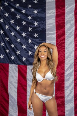 Bir muhteşem Afro-Amerikan mayo model bir stüdyo ortamında Amerikan bayrağı karşı poz