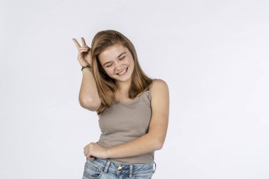 Güzel sarışın bir genç model stüdyo ortamında kameranın önünde eğleniyor.