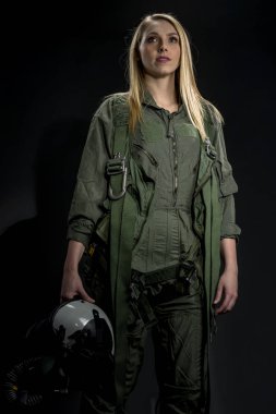 Bir kadın savaş pilotu bir stüdyo ortamında siyah bir arka plan teşkil etmektedir 