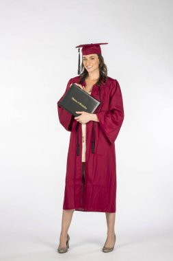 Muhteşem bir esmer model beyaz bir arka plan karşı mezuniyetten sonra bir diploma ile poz