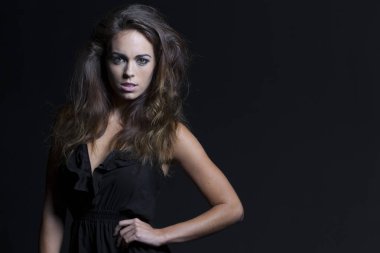 Güzel esmer manken bir stüdyo ortamında teşkil etmektedir.