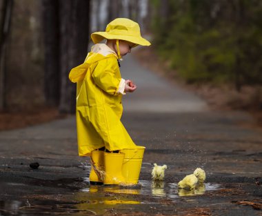 Onun galoş yağmurda zevk çocuk 