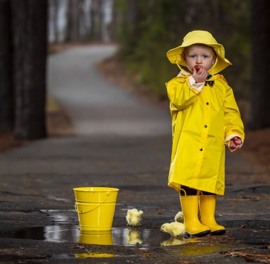 Onun galoş yağmurda zevk çocuk 