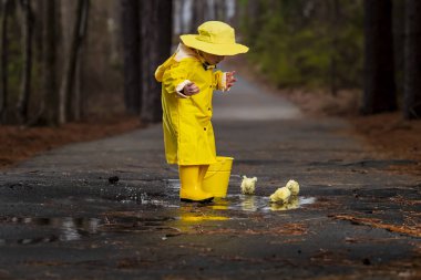 Onun galoş yağmurda zevk çocuk 