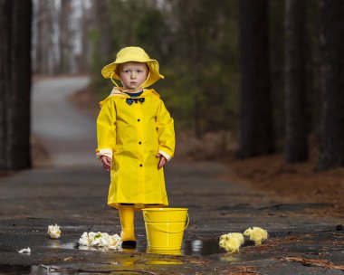 Onun galoş yağmurda zevk çocuk 