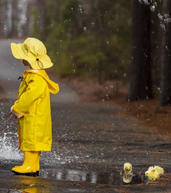 Onun galoş yağmurda zevk çocuk 