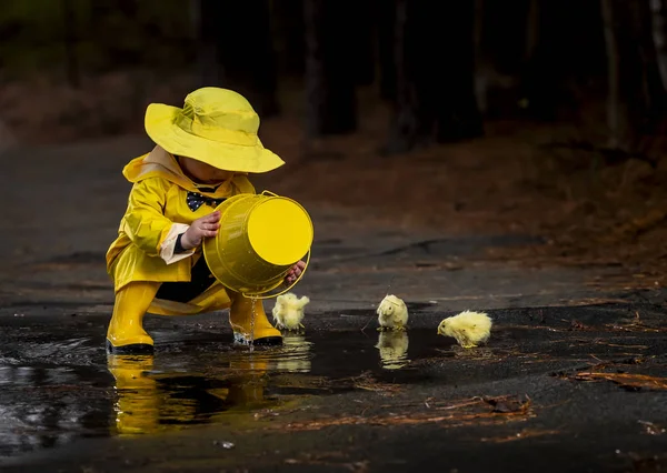 Kind genießt den Regen in seinen Galoshes — Stockfoto