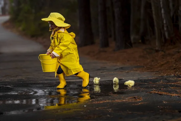 Onun galoş yağmurda zevk çocuk 