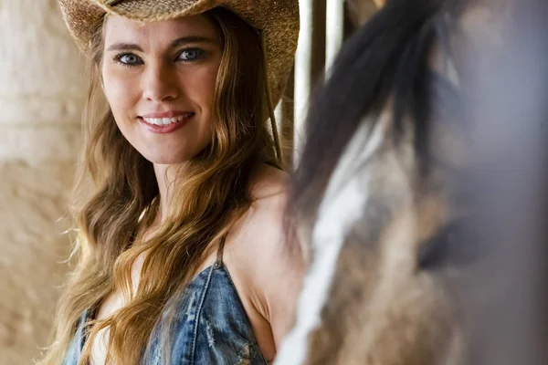 Una encantadora modelo morena hispana posa con un caballo al aire libre en un ambiente hogareño — Foto de Stock