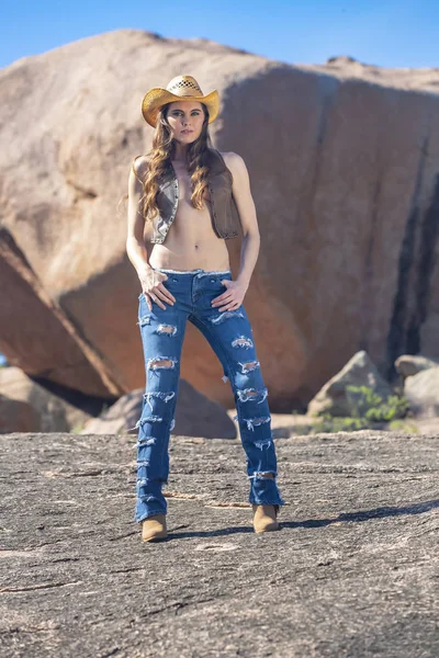 Güzel esmer Cowgirl Model açık havada poz 