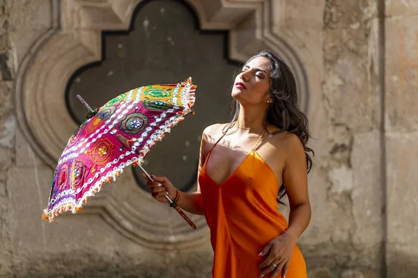 Un bel modello di bruna ispanica si posa all'aperto su un ranch messicano con un ombrellone — Foto Stock