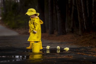 Onun galoş yağmurda zevk çocuk 