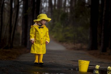 Onun galoş yağmurda zevk çocuk 