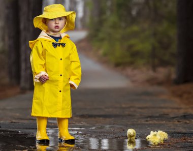 Onun galoş yağmurda zevk çocuk 