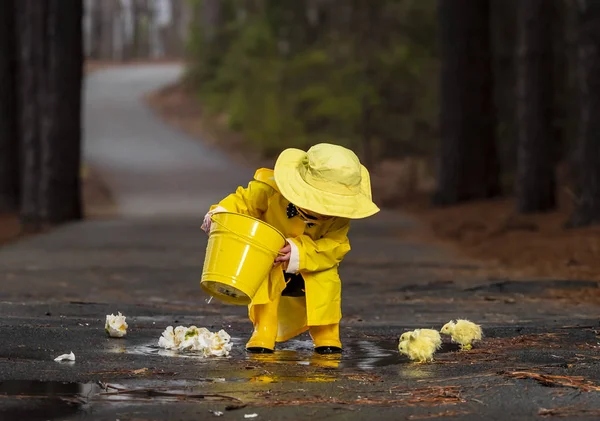 Criança desfrutando da chuva em seus galochas — Fotografia de Stock