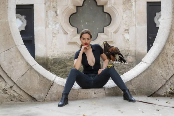 A Lovely Hispanic Brunette Model Poses Outdoors with a Falcon At — стоковое фото