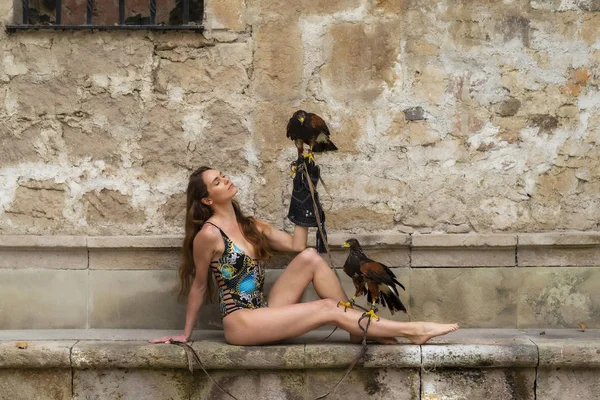 A Lovely Hispanic Brunette Model Poses Outdoors with a Falcon At — стоковое фото