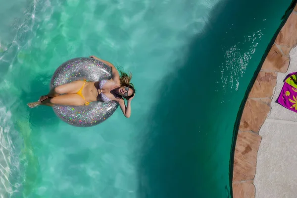 Una encantadora modelo de traje de baño morena disfruta de sus vacaciones en la piscina — Foto de Stock