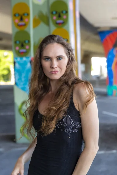 Linda morena modelo posando ao ar livre contra Graffiti — Fotografia de Stock
