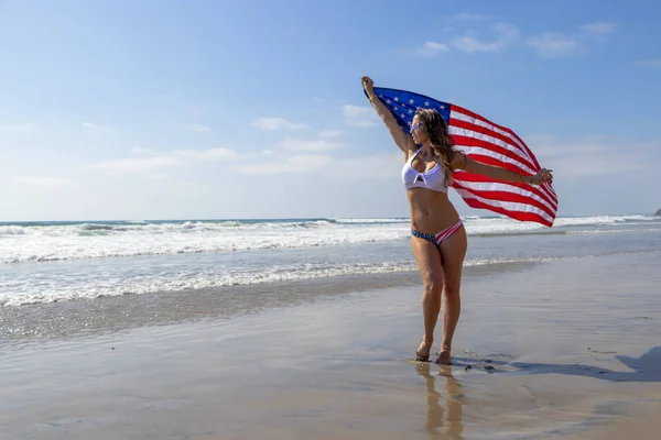 Un beau modèle de brune patriotique pose sur la côte avec une Ame — Photo