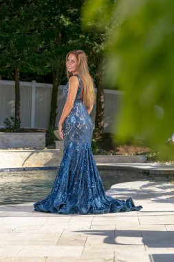 Güzel bir esmer model, mezuniyet balosundan önce havuz başında eğleniyor.