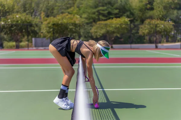 Um modelo loiro adorável joga tênis em um dia quente de verão — Fotografia de Stock