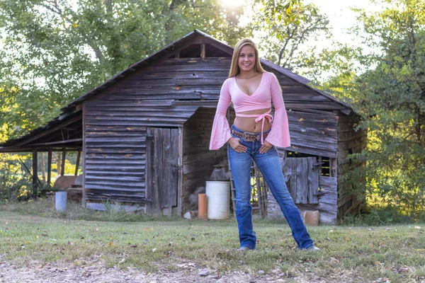 En härlig blond modell njuter av en sommardag utomhus på en gård — Stockfoto