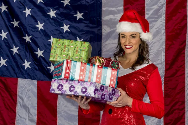 Krásná bruneta model pózování jako elf s dárky na bílém pozadí — Stock fotografie