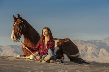 Güzel bir esmer manken, bir yaz günü atını çölde gezdirir. 