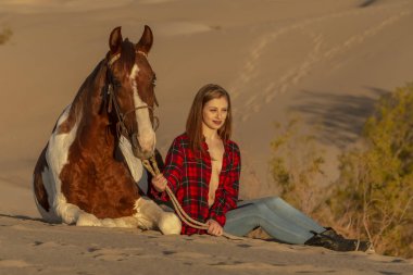 Güzel bir esmer manken, bir yaz günü atını çölde gezdirir. 