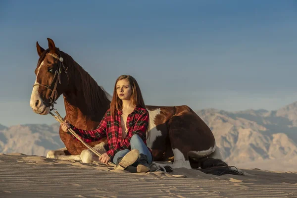 Una encantadora modelo morena pasea su caballo por el desierto en un día de verano — Foto de Stock