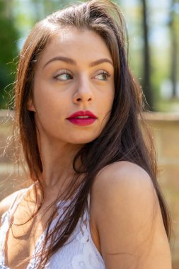 Muhteşem bir esmer model, açık havada bir bahar gününün tadını çıkarıyor. 