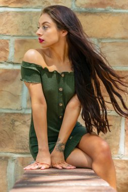 Muhteşem bir esmer model, açık havada bir bahar gününün tadını çıkarıyor. 