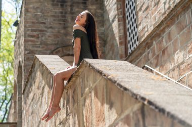 Muhteşem bir esmer model, açık havada bir bahar gününün tadını çıkarıyor. 