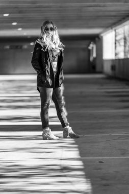 Muhteşem sarışın bir model, bir sonbahar günü park yerinde poz verir.