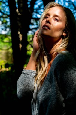 Sarışın bir model, açık havada bahar gününün tadını çıkarıyor. 