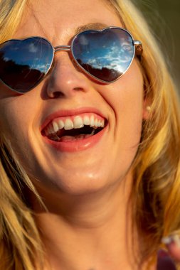 Sarışın bir manken, yaz günlerini dışarıda, parkta geçirmekten zevk alır.