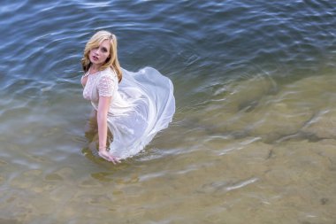 Muhteşem bir sarışın manken, yaz günlerinde gölün tadını çıkarıyor.