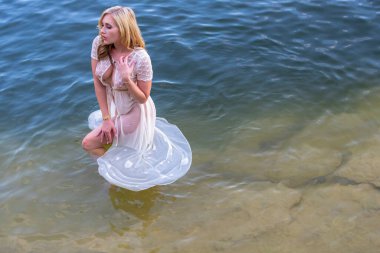 Muhteşem bir sarışın manken, yaz günlerinde gölün tadını çıkarıyor.