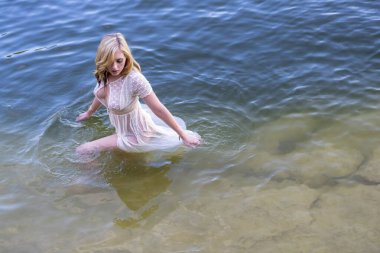 Muhteşem bir sarışın manken, yaz günlerinde gölün tadını çıkarıyor.