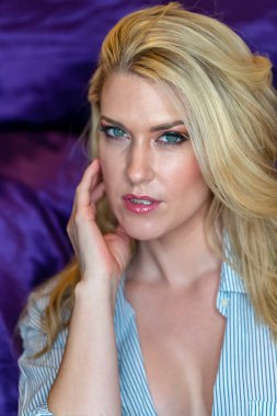 Sarışın bir model ev ortamında iç çamaşırlarıyla poz veriyor.