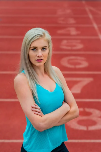 A beautiful young college athlete prepares herself for a track meet at a local university