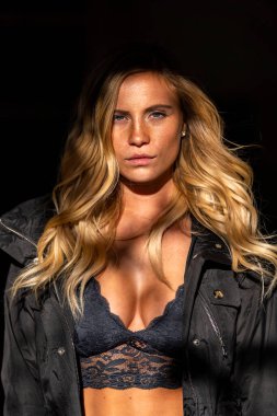 Muhteşem sarışın bir model, bir sonbahar günü park yerinde poz verir.