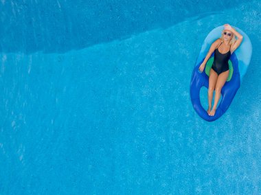 Sarışın bir manken yaz tatilinin tadını çıkarırken bikiniyle poz verir.