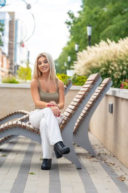 Sarışın bir model yaz gününün tadını çıkarırken dışarıda poz veriyor.