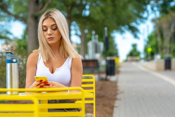 Sarışın bir model yaz gününün tadını çıkarırken dışarıda poz veriyor.