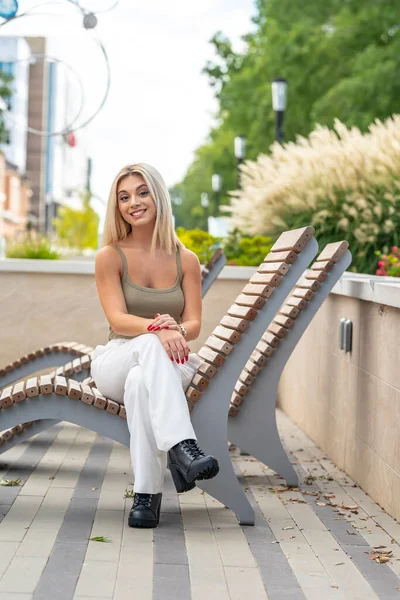 Sarışın bir model yaz gününün tadını çıkarırken dışarıda poz veriyor.